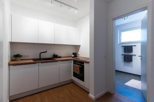 a kitchen with white cabinets and a window at Neu & modern - hej homes mit kostenfreiem Parken in Bad Kissingen