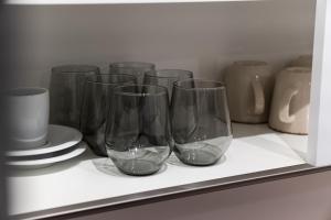 a row of wine glasses sitting on a shelf at Neu & modern - hej homes mit kostenfreiem Parken in Bad Kissingen +14 photos