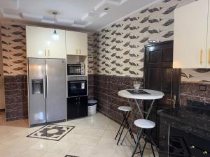 a kitchen with a refrigerator and a table with stools at villa agadir in Glalcha
