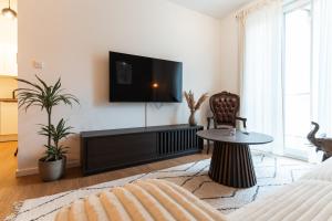 a living room with a flat screen tv on a wall at Neu & modern - hej homes mit kostenfreiem Parken in Bad Kissingen
