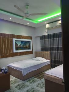 a bedroom with two beds and a green ceiling at Bliss Spa Gulshan - Spa in Gulshan in Bhola