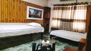 a room with two twin beds and a table at Bliss Spa Gulshan - Spa in Gulshan in Bhola