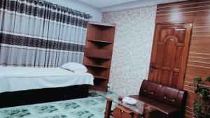 a bedroom with a bed and a chair and a table at Bliss Spa Gulshan - Spa in Gulshan in Bhola