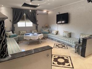 a living room with a couch and a table at villa agadir in Glalcha