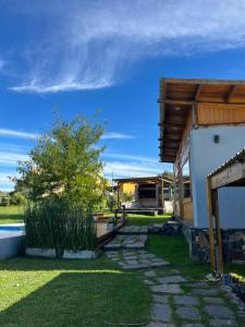 a house with a stone walkway next to a building at Sierras de Canela premium in Tandil