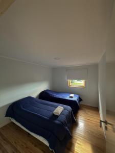 two beds in a room with blue sheets and a window at Sierras de Canela premium in Tandil +16 photos