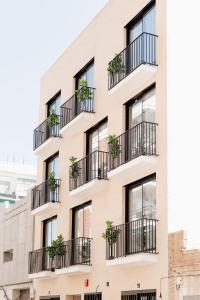 an apartment building with balconies and plants at SuiteStays Marino Albesa - Ayora, Valencia in Valencia