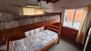a bedroom with two bunk beds and a window at Cabañas Ohiggins in Dalcahue