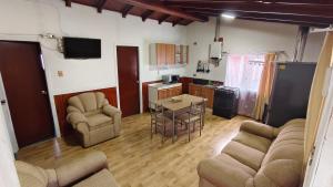 a living room with a table and chairs and a kitchen at Cabañas Ohiggins in Dalcahue
