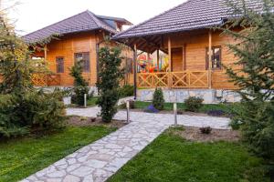 a wooden house with a stone path in front of it at Kedar selo Goč in Goč