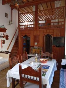 a dining room with a table and a tv at Myrto's traditional house in Skiros