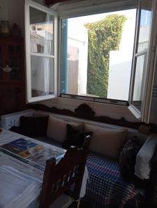 a room with two windows and a bed with two chairs at Myrto's traditional house in Skiros +4 photos