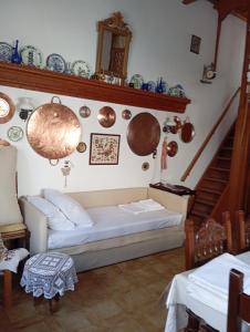 a living room with a couch and plates on the wall at Myrto's traditional house in Skiros