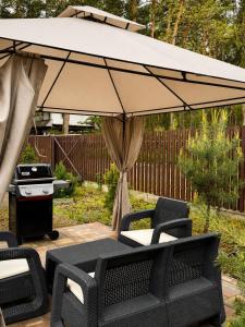 a patio with a table and chairs under an umbrella at Joy WoodRest in Voropayev +38 photos