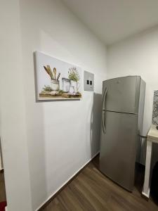 a kitchen with a refrigerator and some plants on a shelf at Nice downtown apartment Veracruz in Veracruz