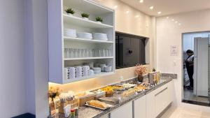 a kitchen with a counter with food on it at Hotel Moriah in Umuarama +31 photos