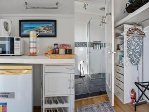a kitchen with a desk and a shower at King bed studio seperate entry sauna pool garden view in Terranora