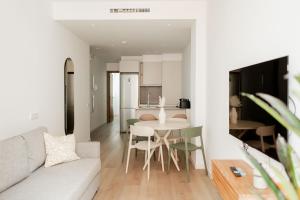 a living room and kitchen with a couch and a table at SuiteStays Marino Albesa - Ayora, Valencia in Valencia