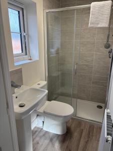 a bathroom with a sink and a toilet and a shower at Lion Gardens- The Space in Leyland +6 photos
