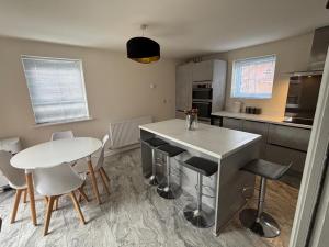 a kitchen with a white table and chairs and a counter at Lion Gardens- The Space in Leyland