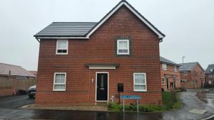 a red brick house with a solar roof at Lion Gardens- The Space in Leyland