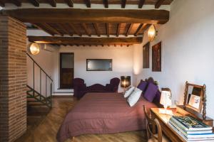 a bedroom with a bed and a couch and a table at Casa Marelli in Castelmuzio