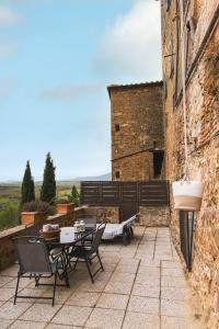 a patio with a table and chairs next to a building at Casa Marelli in Castelmuzio