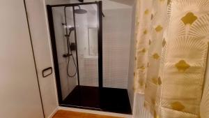 a shower with a glass door in a bathroom at Ma chaumiere in Les Cammazes +10 photos