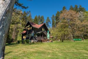 a large house on a field with a swing at Špengel chata in Smižany