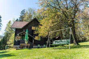 a house with a swing in front of it at Špengel chata in Smižany +20 photos