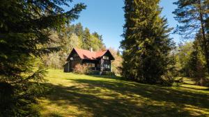 an old house in the middle of a field with trees at Špengel chata in Smižany