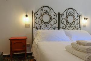 a bedroom with a white bed with a metal headboard at Spighe e Fenicotteri in Modica