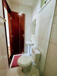 a bathroom with a toilet and a sink and a shower at Pousada Sol & Mar Jacaraìpe ES in Serra +41 photos