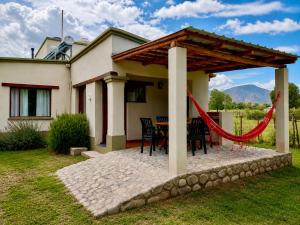 a patio with a table and chairs in front of a house at Entre Montañas in Tafí del Valle