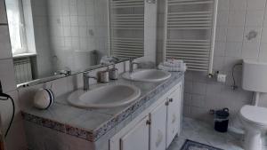 a bathroom with two sinks and a toilet at L'albero del druido in Villastellone +10 photos