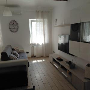 a living room with a couch and a clock on the wall at L'albero del druido in Villastellone