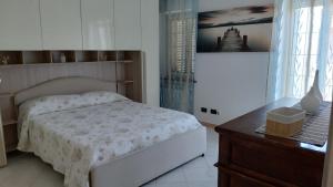 a bedroom with a white bed and a wooden table at L'albero del druido in Villastellone