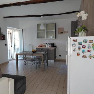 a kitchen and dining room with a table and a refrigerator at L'albero del druido in Villastellone