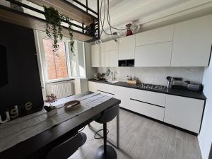 a kitchen with white cabinets and a wooden table at alloggioaltorrione in Citerna +21 photos