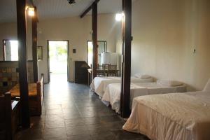 a hotel room with three beds and a mirror at Pousada Corujas in Cajuru do Sul +72 photos