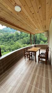 a room with a wooden table and benches on a balcony at Serona Apart & Bungalow in Çamlıhemşin