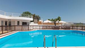 a large blue swimming pool in front of a building at CHIOS HOTEL in Katarráktis