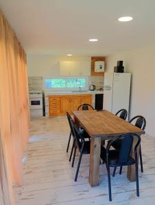 a kitchen with a wooden table and chairs at Complejo ruka del pinar in San Ignacio +1 photo