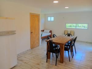 a dining room with a wooden table and chairs at Complejo ruka del pinar in San Ignacio