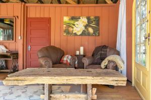a living room with two chairs and a table at Cabana Paiol de Baixo in Curitiba +18 photos