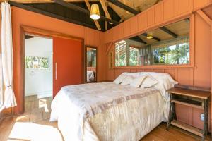 a bedroom with orange walls and a bed in it at Cabana Paiol de Baixo in Curitiba