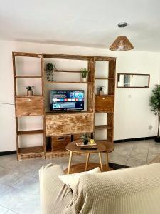 a living room with a tv and a table at Studio Cosy et Moderne in Saint-Ambroix
