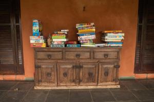 a pile of books sitting on top of a woodenoire at Pousada Corujas in Cajuru do Sul