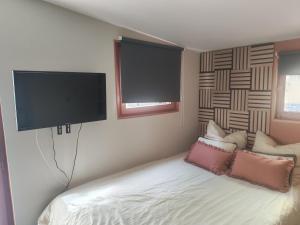 a bedroom with a bed with a flat screen tv on the wall at Studio équipé proche Stade de France in Épinay-sur-Seine