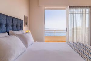 a bedroom with a bed and a view of the ocean at CHIOS HOTEL in Katarráktis